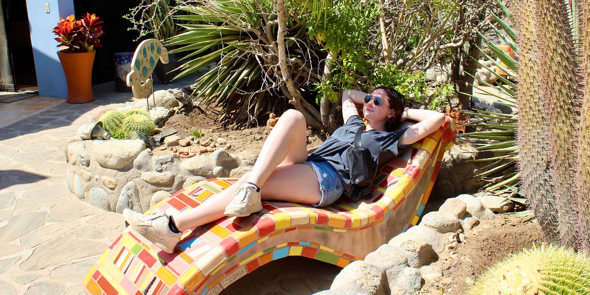 Person in shorts lounging on a beach chair.