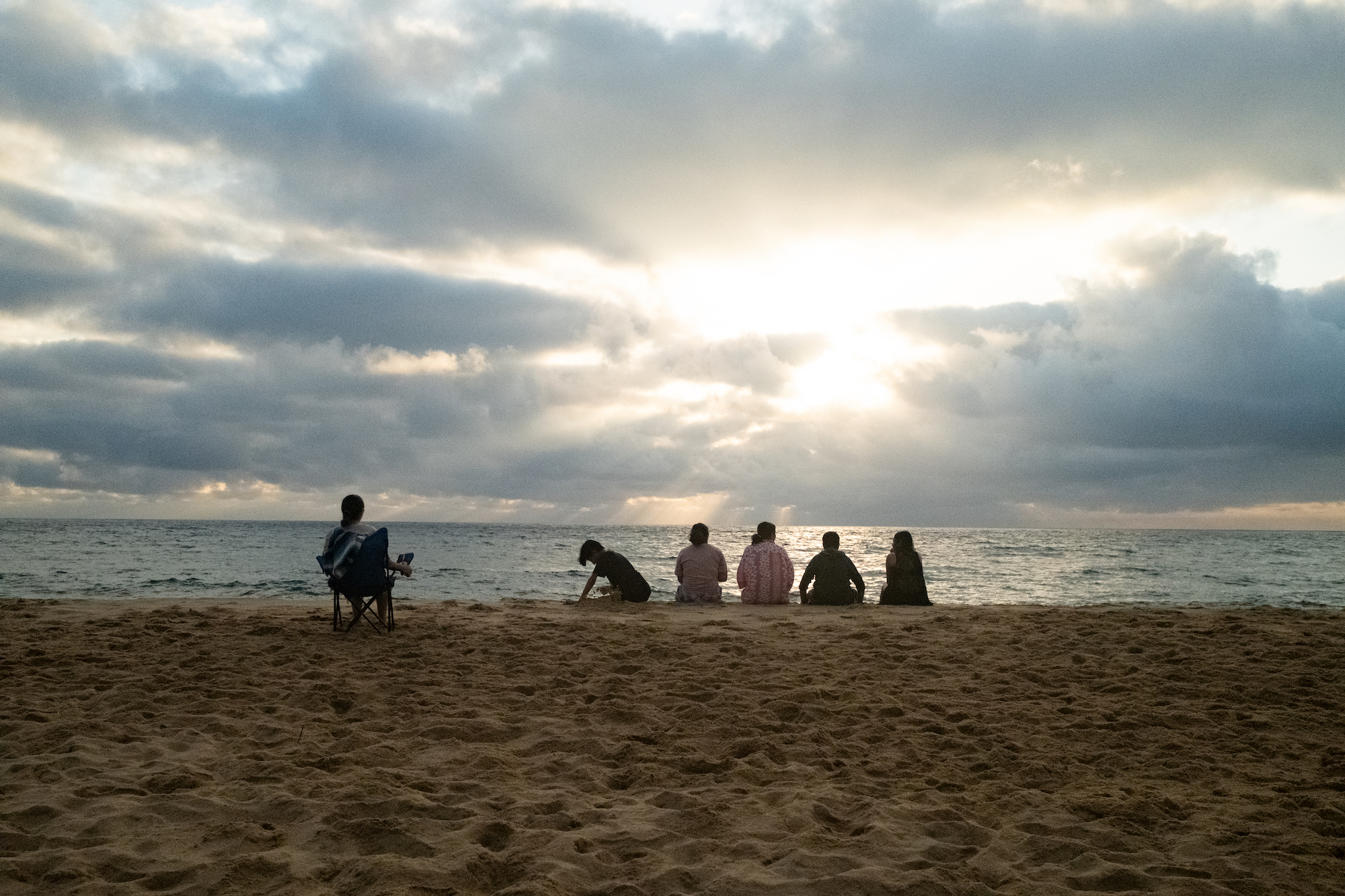 Students sit on the beach.