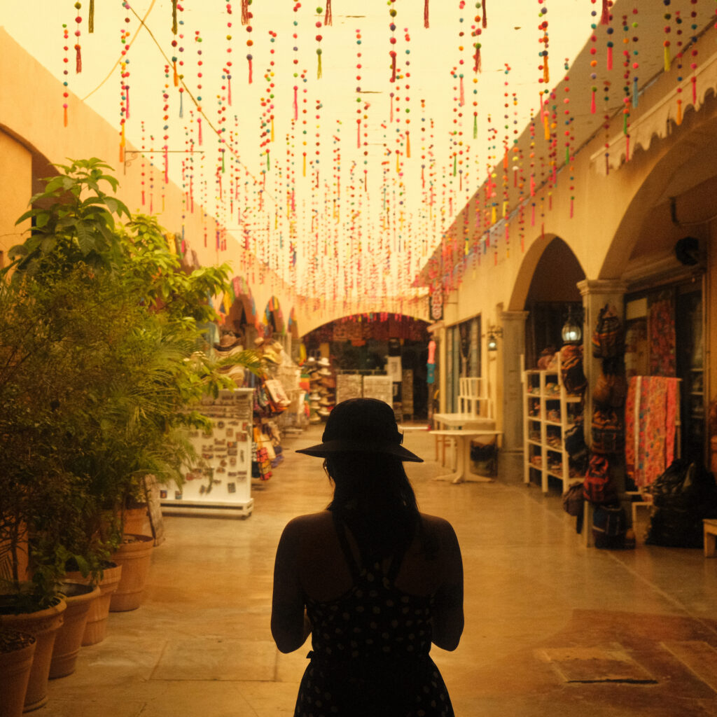 Woman silhouetted against a street strung with flags.